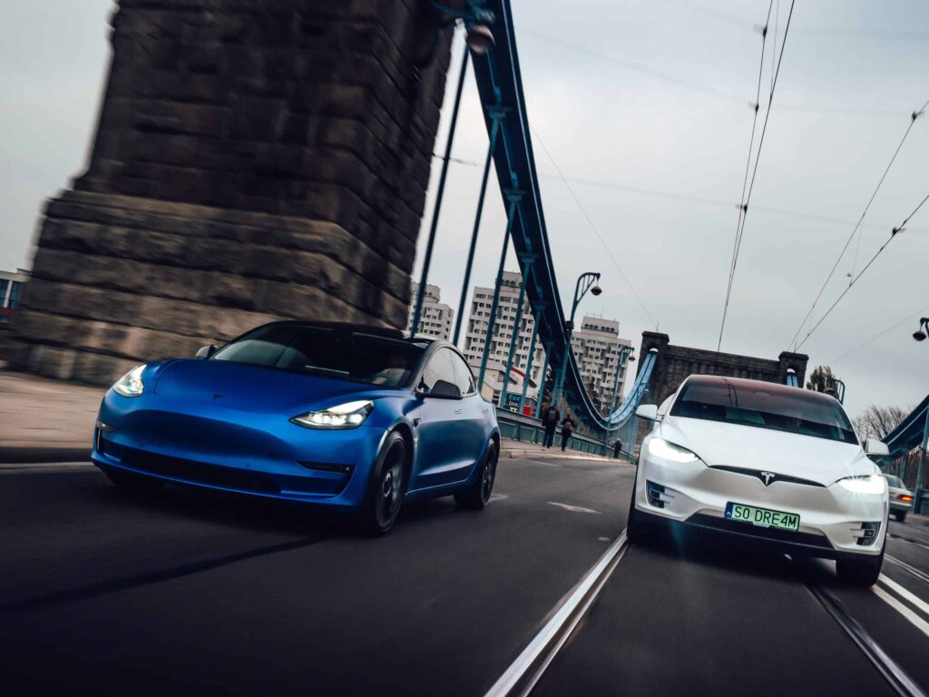 Tesla Model 3 Performance i Tesla Model X na drodze w ruchu.